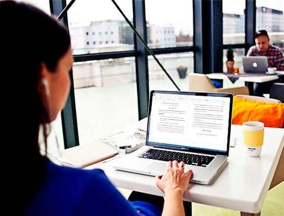 Using a computer at Pro-Paper office to write a compare and contrast essay